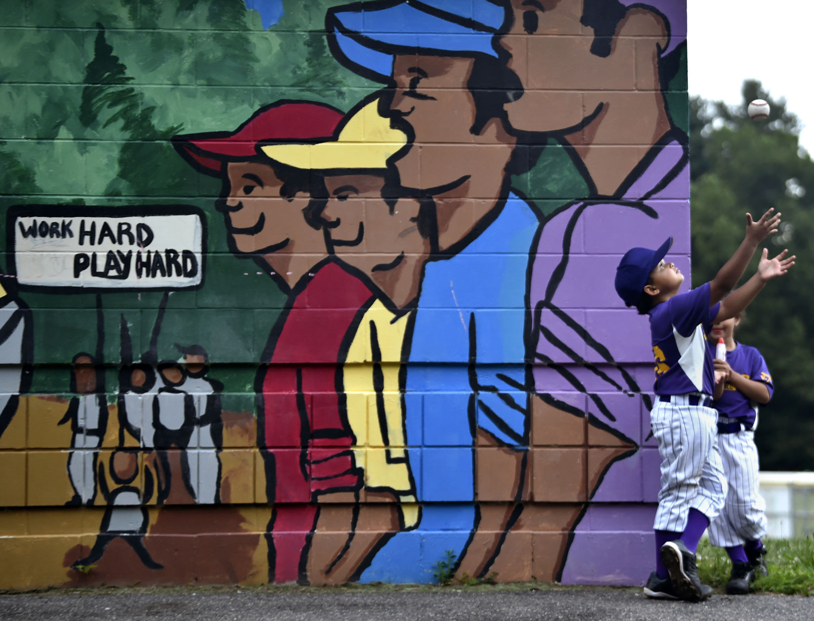 The Ques Little Leaguer Jeremiah Amaro catches a baseball after his game in the Hartford Northend 5-8 (year) Little League at Waverly Field on June 19, 2019.